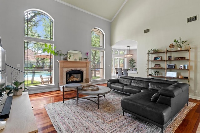 205 Champion Dr, Lakeway, TX 78734 - living area featuring high vaulted ceiling, arched walkways, ornamental molding, wood finished floors, and plenty of natural light