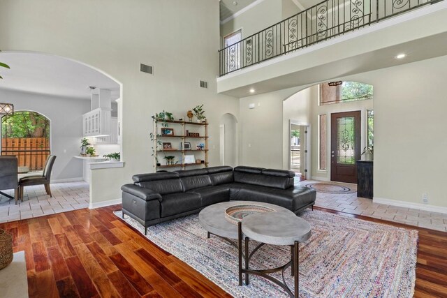 205 Champion Dr, Lakeway, TX 78734 - living room featuring a towering ceiling, arched walkways, and wood finished floors
