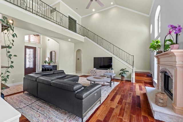 205 Champion Dr, Lakeway, TX 78734 - living room featuring arched walkways, high vaulted ceiling, a ceiling fan, stairs, and ornamental molding