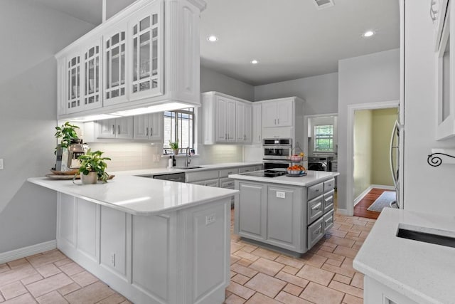 205 Champion Dr, Lakeway, TX 78734 - kitchen with backsplash, white cabinetry, a peninsula, glass insert cabinets, and recessed lighting