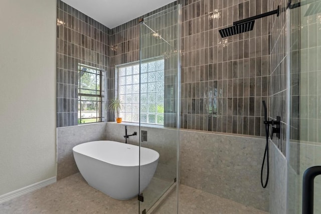 205 Champion Dr, Lakeway, TX 78734 - bathroom with a tile shower, a freestanding bath, tile patterned flooring, and tile walls