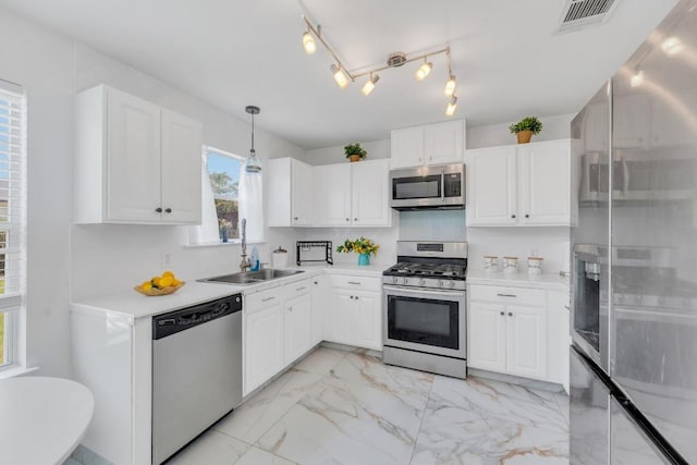 18400 Sun Haven Cv, Elgin, TX 78621 - kitchen with stainless steel appliances, a sink, light marble finish floors, and white cabinetry