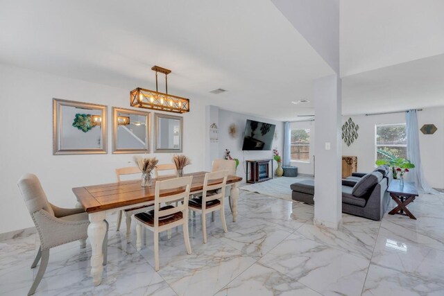18400 Sun Haven Cv, Elgin, TX 78621 - dining area featuring light marble finish flooring and a chandelier