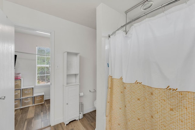 18400 Sun Haven Cv, Elgin, TX 78621 - full bathroom with wood finished floors, toilet, curtained shower, and baseboards