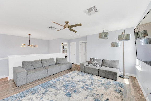 18400 Sun Haven Cv, Elgin, TX 78621 - living room featuring wood finished floors, a chandelier, baseboards, and a ceiling fan