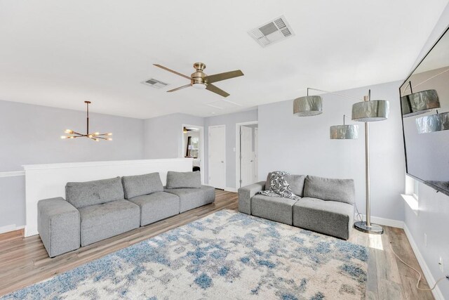 18400 Sun Haven Cv, Elgin, TX 78621 - living area with wood finished floors, a chandelier, and a ceiling fan