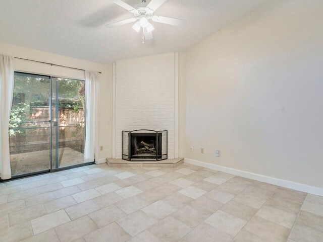 3815 Menchaca Rd Unit 19, Austin, TX 78704 - unfurnished living room with a tile fireplace, ceiling fan, light tile patterned flooring, baseboards, and a textured ceiling