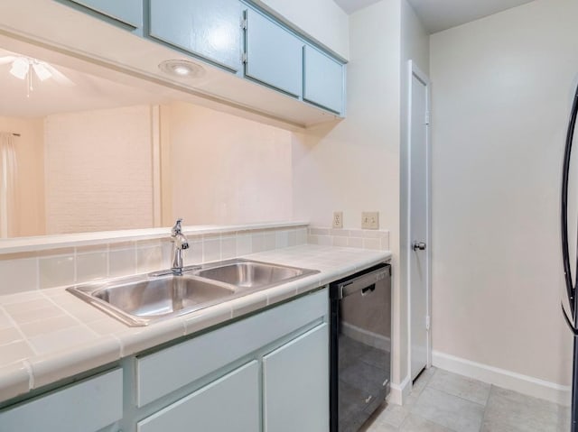 3815 Menchaca Rd Unit 19, Austin, TX 78704 - kitchen featuring black dishwasher, tile countertops, a sink, baseboards, and light tile patterned floors