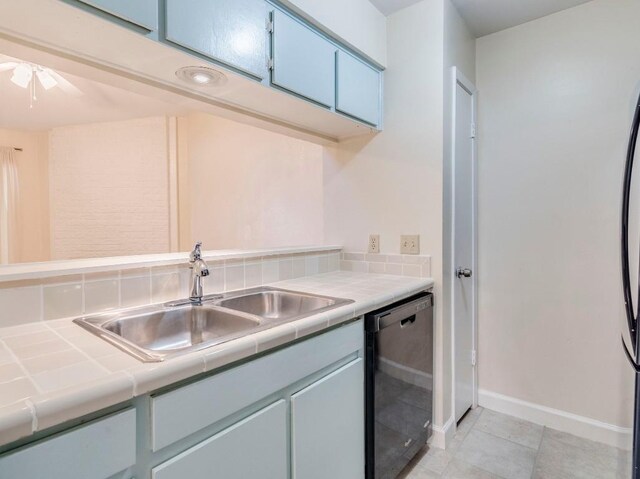 3815 Menchaca Rd Unit 19, Austin, TX 78704 - kitchen featuring dishwashing machine, tile countertops, a sink, and baseboards