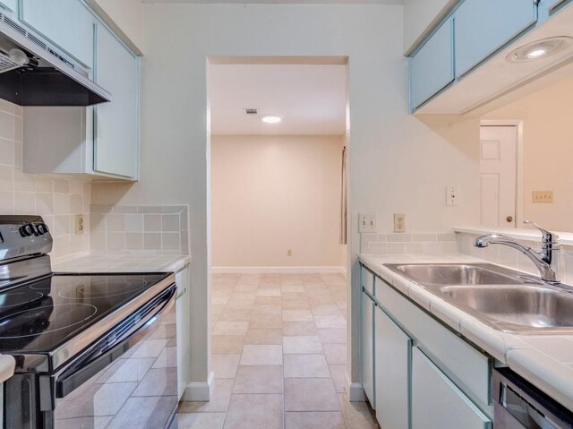 3815 Menchaca Rd Unit 19, Austin, TX 78704 - kitchen with black electric range, under cabinet range hood, dishwasher, a sink, and blue cabinetry