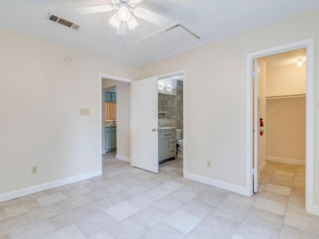 3815 Menchaca Rd Unit 19, Austin, TX 78704 - unfurnished bedroom with attic access, a spacious closet, a closet, ensuite bathroom, and light tile patterned floors