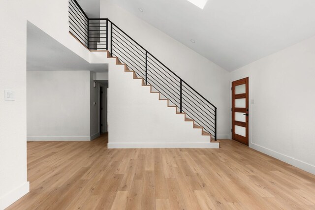 2716 Gettysburg Dr, Austin, TX 78745 - entrance foyer with stairs, baseboards, light wood-type flooring, and a high ceiling