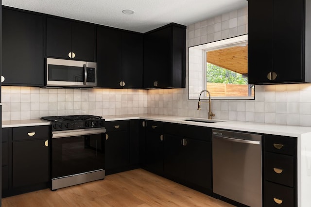 2716 Gettysburg Dr, Austin, TX 78745 - kitchen with stainless steel appliances, dark cabinets, a sink, and light countertops