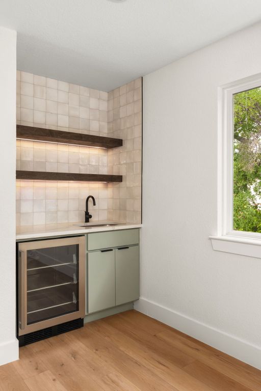 2716 Gettysburg Dr, Austin, TX 78745 - indoor wet bar with beverage cooler, light wood-style floors, backsplash, and baseboards