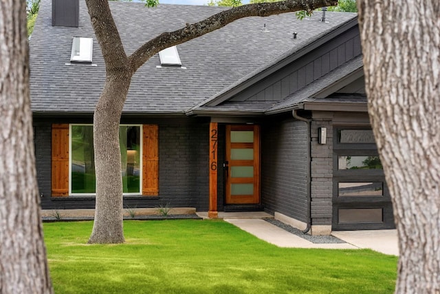 2716 Gettysburg Dr, Austin, TX 78745 - view of front facade with a front lawn, a shingled roof, and brick siding