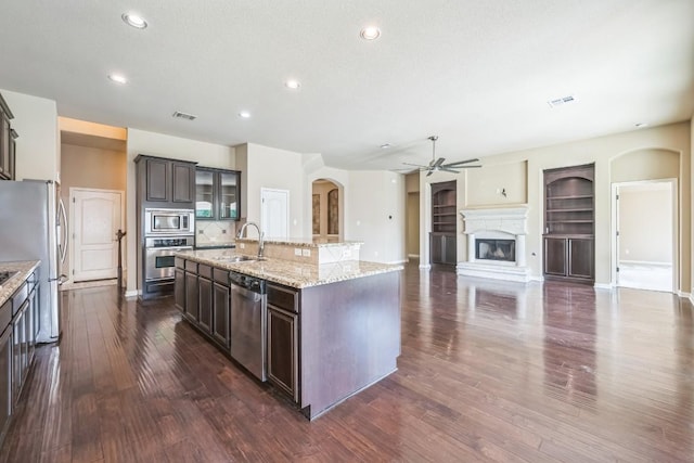 20125 Chayton Cir, Pflugerville, TX 78660 - kitchen featuring stainless steel appliances, arched walkways, a sink, a ceiling fan, and a kitchen island with sink
