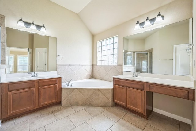 20125 Chayton Cir, Pflugerville, TX 78660 - bathroom with a shower stall, lofted ceiling, a garden tub, tile patterned floors, and two vanities