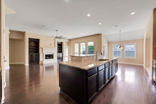 20125 Chayton Cir, Pflugerville, TX 78660 - kitchen with a sink, healthy amount of natural light, a fireplace with raised hearth, a ceiling fan, and recessed lighting