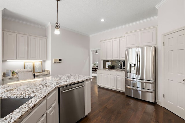 11 Meadow Run, Round Rock, TX 78664 - kitchen featuring appliances with stainless steel finishes, dark wood-type flooring, ornamental molding, white cabinetry, and backsplash