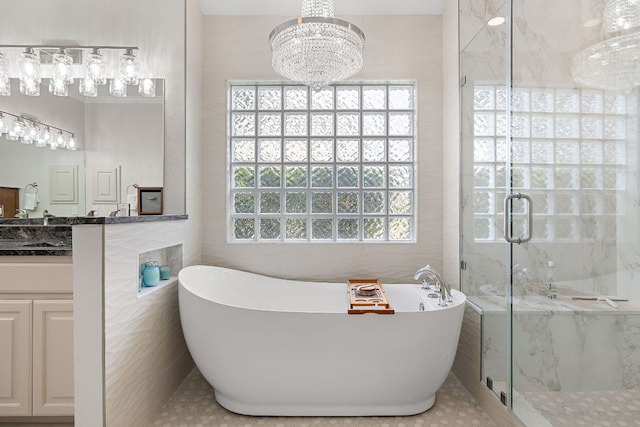 11 Meadow Run, Round Rock, TX 78664 - full bathroom with a marble finish shower, a freestanding tub, tile walls, vanity, and a chandelier
