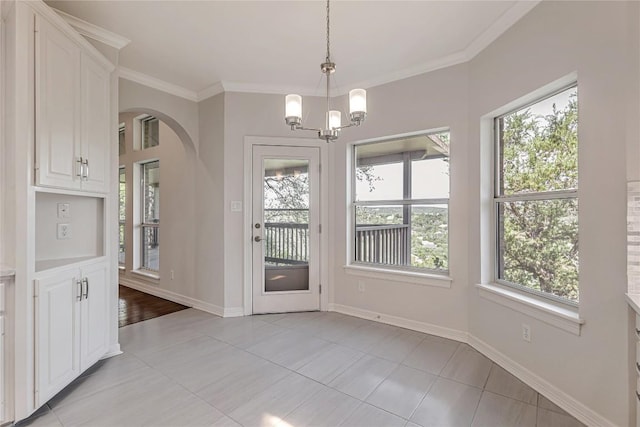 9010 Bluegrass Dr, Austin, TX 78759 - unfurnished dining area featuring arched walkways, a chandelier, light tile patterned floors, crown molding, and baseboards
