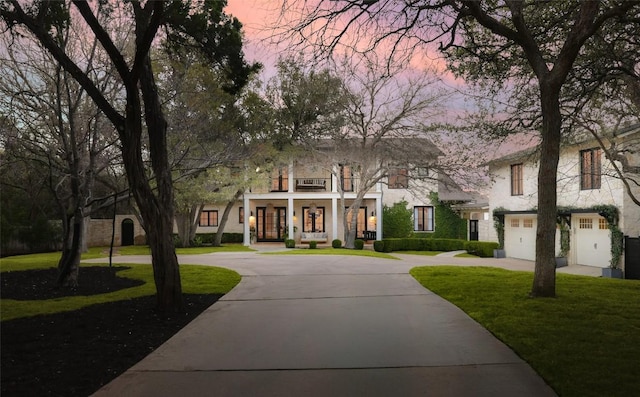 102 Crestwood Ct, Austin, TX 78746 - view of front of house featuring curved driveway, a front lawn, covered porch, and an attached garage