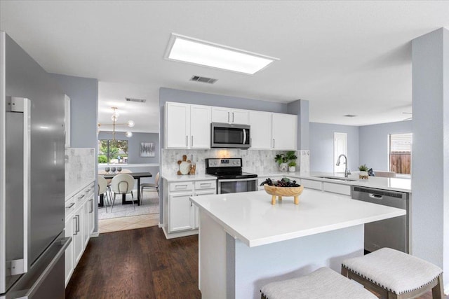 1222 Minerva St, Austin, TX 78753 - kitchen with stainless steel appliances, a sink, decorative backsplash, light countertops, and a breakfast bar