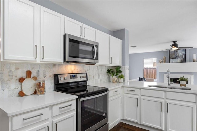 1222 Minerva St, Austin, TX 78753 - kitchen featuring appliances with stainless steel finishes, a sink, white cabinets, light countertops, and tasteful backsplash