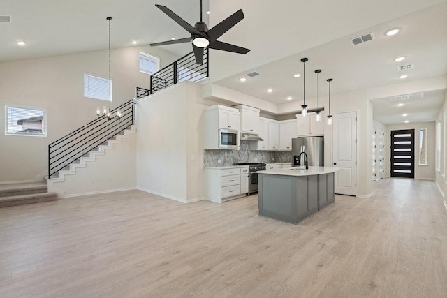 2008 Kit Cir, Austin, TX 78758 - kitchen with stainless steel appliances, baseboards, under cabinet range hood, light countertops, and light wood-type flooring