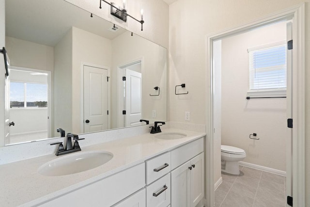 2008 Kit Cir, Austin, TX 78758 - full bathroom featuring toilet, plenty of natural light, double vanity, and baseboards