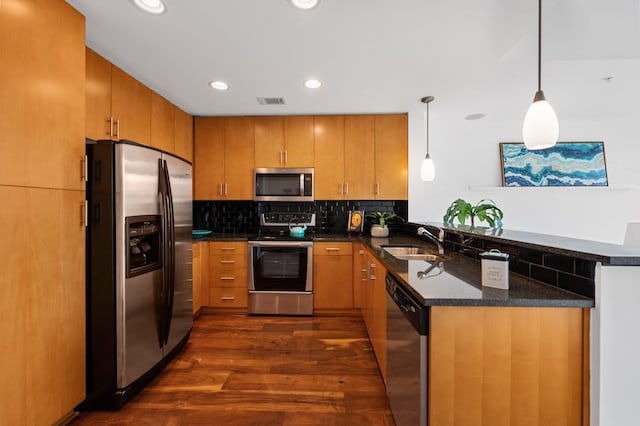 360 Nueces St Unit 1407, Austin, TX 78701 - kitchen with stainless steel appliances, a sink, a peninsula, dark wood finished floors, and tasteful backsplash