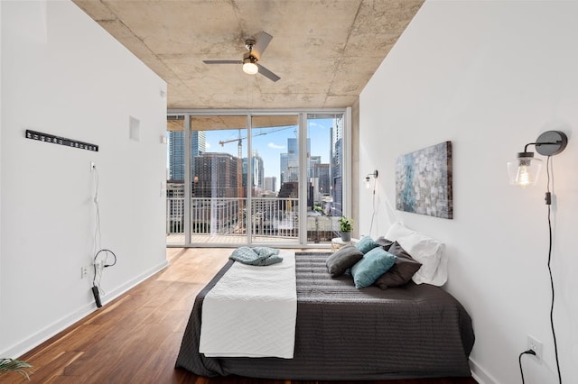 360 Nueces St Unit 1407, Austin, TX 78701 - bedroom featuring a view of skyline, access to exterior, wood finished floors, a wall of windows, and baseboards