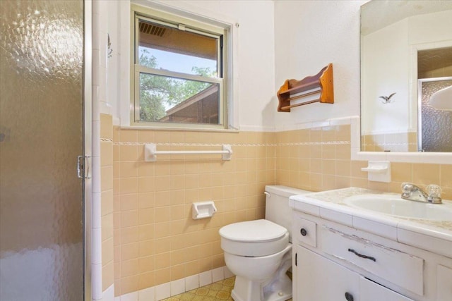 4412 Briar Cliff Rd, Temple, TX 76502 - full bath featuring a shower stall, tile walls, vanity, toilet, and a wainscoted wall
