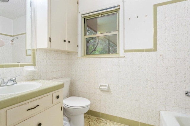 4412 Briar Cliff Rd, Temple, TX 76502 - bathroom featuring tile walls, toilet, vanity, and bathing tub / shower combination