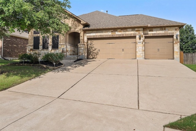 2944 Castellan Ln, Round Rock, TX 78665 - french country home featuring stone siding, concrete driveway, a garage, and a shingled roof