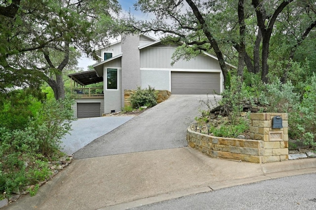 2009 S Oak Canyon Rd, Austin, TX 78746 - mid-century modern home with driveway, a garage, and stone siding