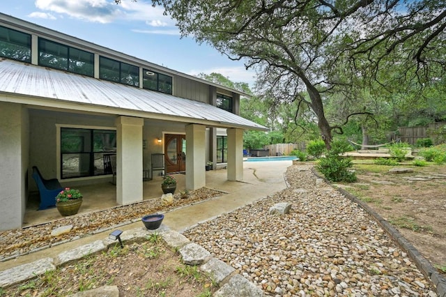 2009 S Oak Canyon Rd, Austin, TX 78746 - rear view of property with stucco siding, a patio, and metal roof
