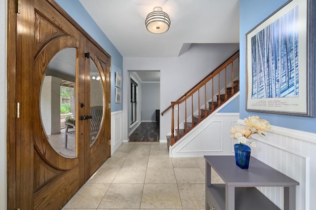 2009 S Oak Canyon Rd, Austin, TX 78746 - entrance foyer with wainscoting, stairs, a decorative wall, and light tile patterned flooring