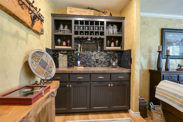 107 Lachite Unit 6, Horseshoe Bay, TX 78657 - indoor wet bar featuring light wood finished floors, a textured wall, and tasteful backsplash