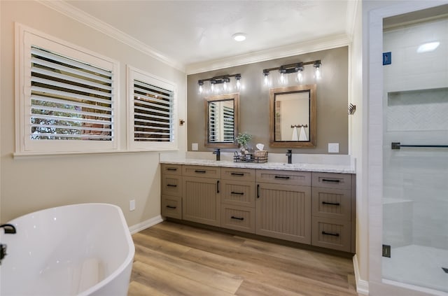 107 Lachite Unit 6, Horseshoe Bay, TX 78657 - bathroom with a stall shower, ornamental molding, a soaking tub, wood finished floors, and double vanity