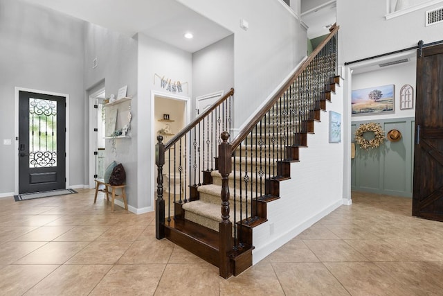 2516 Rusty Spur, Leander, TX 78641 - tiled foyer featuring a high ceiling, stairway, a barn door, baseboards, and recessed lighting
