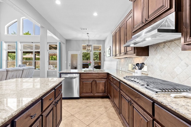 2516 Rusty Spur, Leander, TX 78641 - kitchen with stainless steel appliances, under cabinet range hood, a sink, backsplash, and light tile patterned floors
