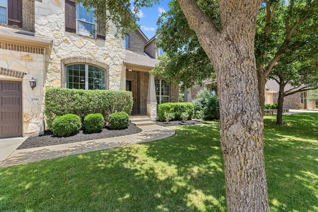 2516 Rusty Spur, Leander, TX 78641 - view of front of home with stone siding, a front yard, and a garage