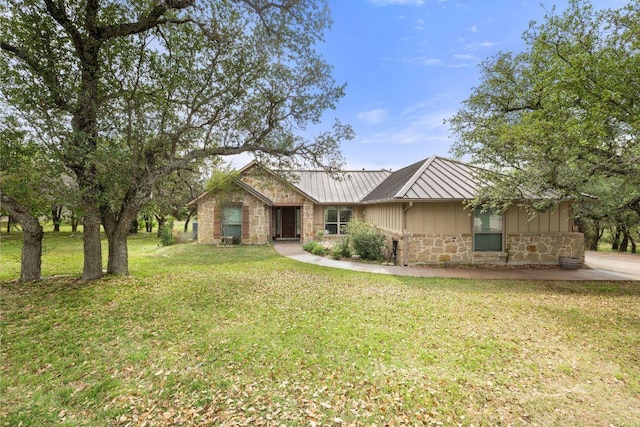 215 Maverick Cir, Horseshoe Bay, TX 78657 - view of front of house featuring stone siding, board and batten siding, a front lawn, and metal roof