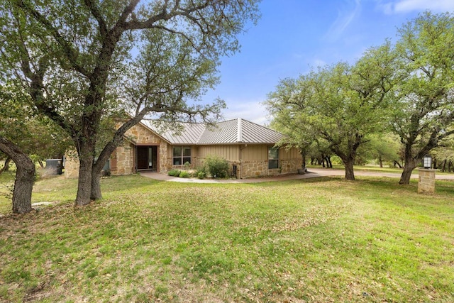 215 Maverick Cir, Horseshoe Bay, TX 78657 - view of front of property with stone siding, a front yard, a standing seam roof, and metal roof