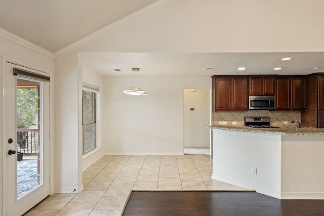 215 Maverick Cir, Horseshoe Bay, TX 78657 - kitchen with stainless steel appliances, decorative backsplash, crown molding, vaulted ceiling, and a sink