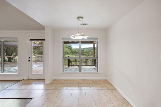 215 Maverick Cir, Horseshoe Bay, TX 78657 - unfurnished dining area featuring a chandelier, baseboards, and light tile patterned flooring