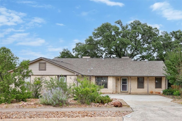 612 Tumlinson Fort Dr, Leander, TX 78641 - ranch-style home with concrete driveway, roof with shingles, stone siding, and a chimney