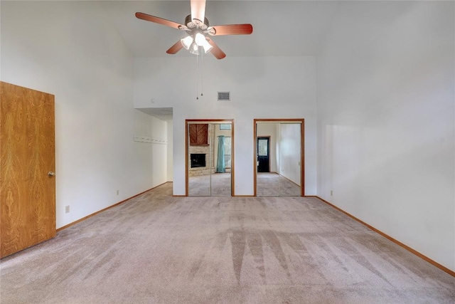 612 Tumlinson Fort Dr, Leander, TX 78641 - unfurnished bedroom with two closets, carpet floors, high vaulted ceiling, a brick fireplace, and baseboards