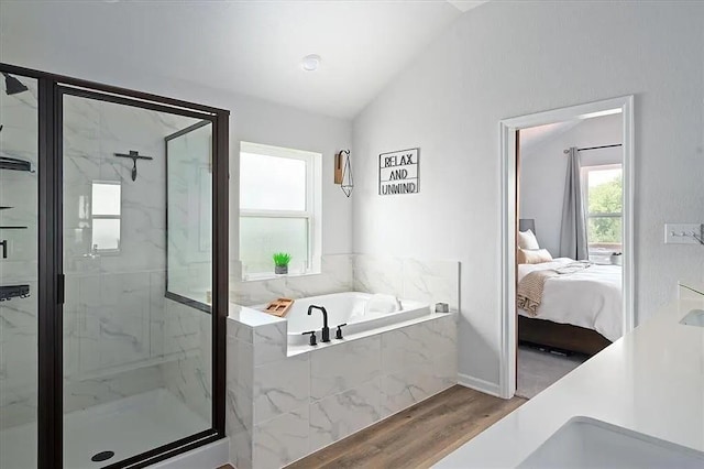 108 Charles Zanco Dr, Bastrop, TX 78602 - ensuite bathroom with lofted ceiling, wood finished floors, a marble finish shower, and a garden tub